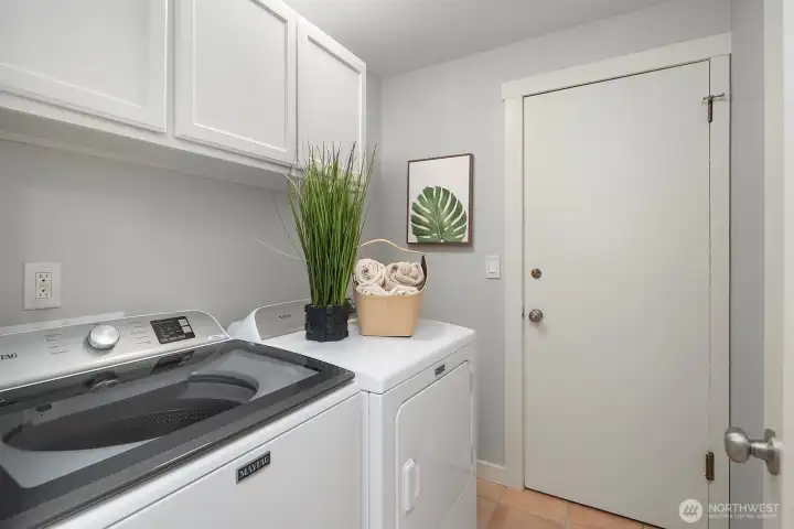 The lower level features its own dedicated laundry space, complete with a full-size washer and dryer and ample white cabinetry for storage — a highly practical amenity that adds exceptional convenience and independence to the ADU. This thoughtful addition makes the lower level truly self-sufficient for extended family or rental use.