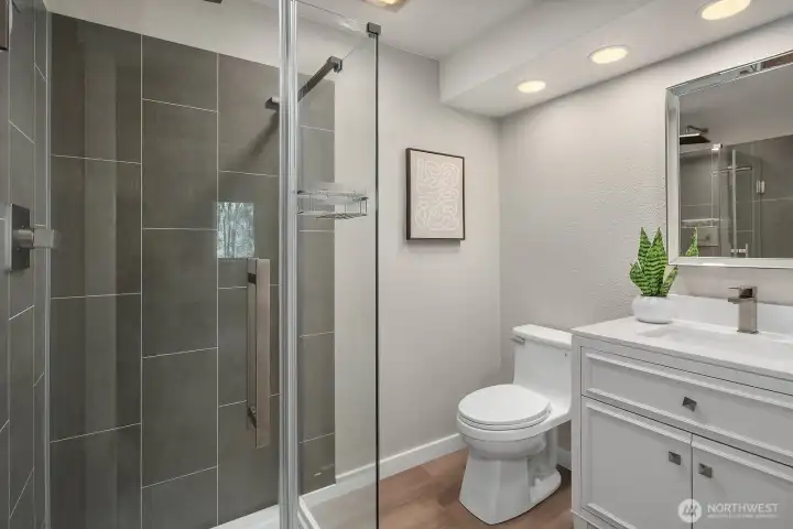 This beautifully updated lower level 3/4 bath features a sleek, floor-to-ceiling tiled walk-in shower, a crisp white vanity with modern fixtures, and clean contemporary finishes throughout. Thoughtfully designed to serve the ADU with style and functionality, this polished bath ensures lower level occupants enjoy the same quality updates found throughout the entire home.