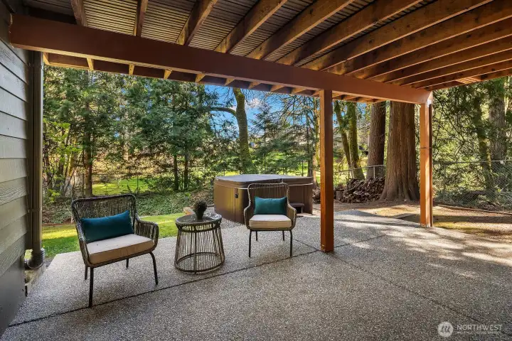 The lower level patio offers a shaded, ground-level outdoor retreat perfect for relaxing or entertaining, with charming seating areas framed by stunning views of the lush, private backyard and surrounding evergreens. Accessible directly from the ADU via private slider entrance, this inviting patio seamlessly extends the lower level's independent living experience into the outdoors.