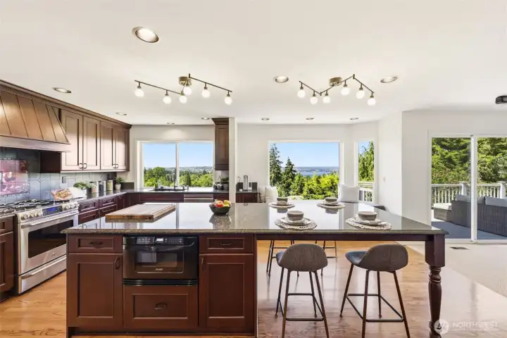 A generous chef’s kitchen with a large center island, breakfast bar, ample storage, and beautiful hardwood floors.