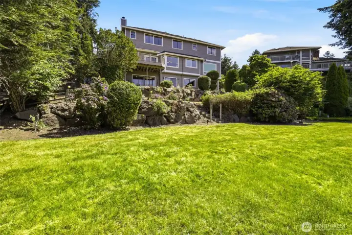 A broad backyard lawn offers space to play, relax, and enjoy the setting.