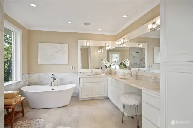 Resort style large master bathroom with gorgeous quartzite countertops and vanity area, real marble shower surround and heated tile flooring.  There's even a view from the soaking tub, truly an experience to enjoy each morning.