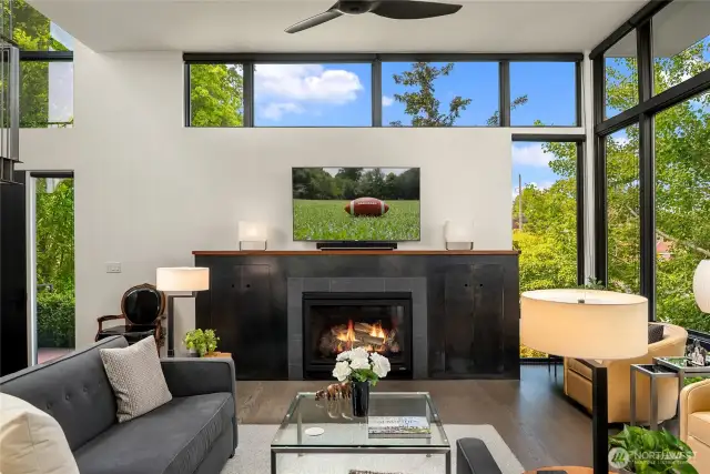 The gas fireplace is encased in a custom blackened steel surround with storage on each side.