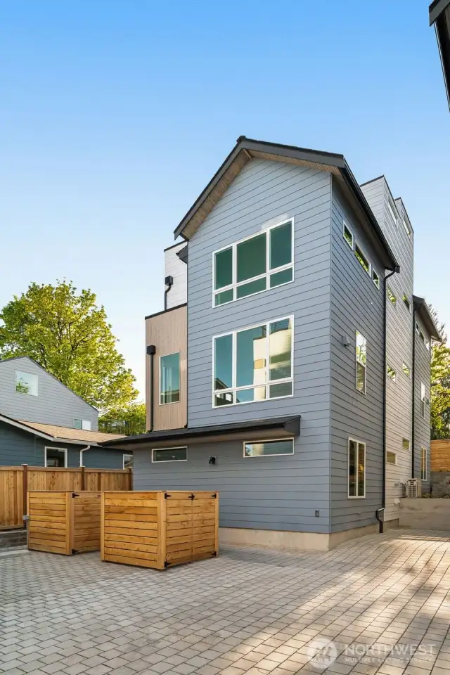 A modern façade with clean lines and natural textures sets the tone for refined living in this new construction gem.