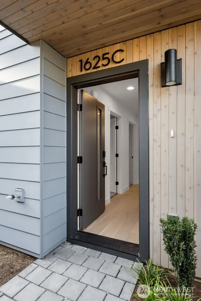 A welcoming private entry accented by vertical cedar slats and sleek black trim creates a stylish first impression.