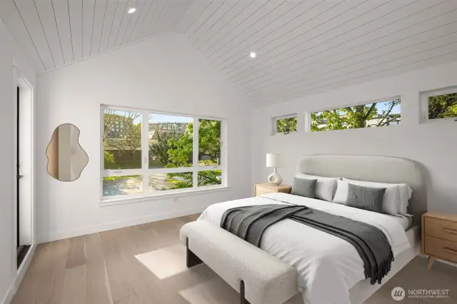 Vaulted ceilings and horizontal windows draw your eyes upward, creating a serene and airy retreat in the upper-level bedroom.
