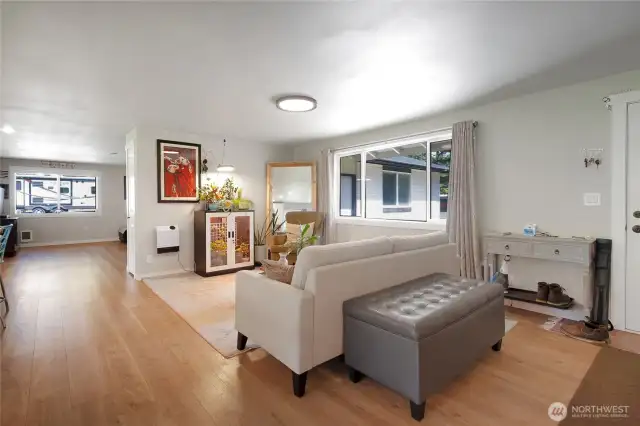 Open space living room off kitchen and front door to right.