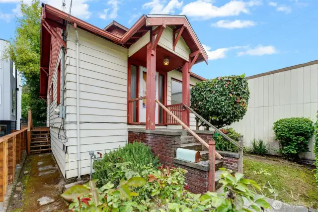 Petite front yard has established shrubs and hedging.