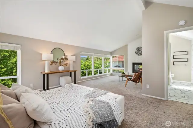 Walls of windows that frame the view and a romantic fireplace in the sitting area of the primary bedroom.