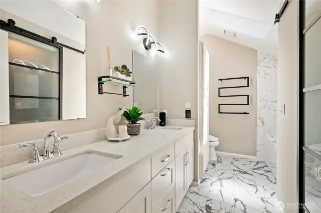 Brand-new spa inspired primary bath with heated floor and heated towel rack.