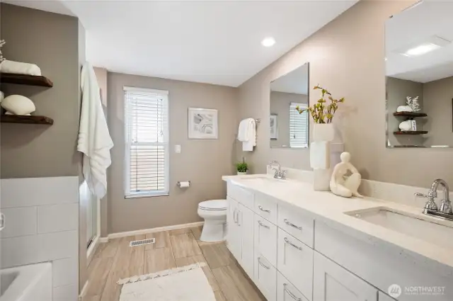 Remodeled full bath on lower level with dual sink vanity, soaking tub, and separate shower.