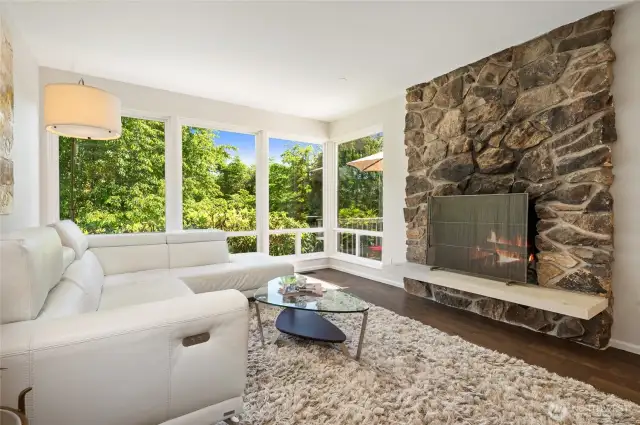 Living room with floor-to-ceiling windows, and cozy fireplace.