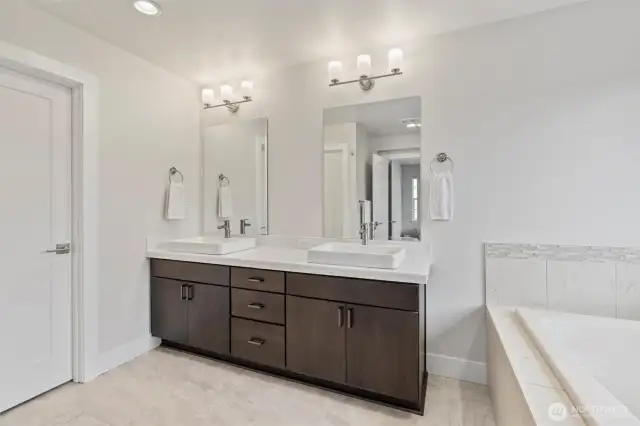 Indulge in your primary bathroom's luxurious amenities, featuring a soaking tub, spacious shower, and double sinks