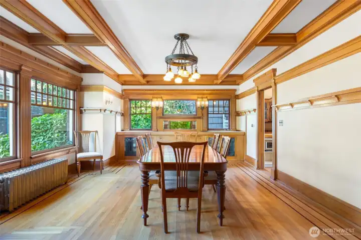 Beautiful built-ins are surrounded by windows and nature outside in the formal dining room.