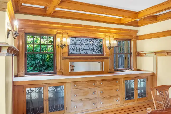 Beautiful built-ins are surrounded by windows and nature outside in the formal dining room.