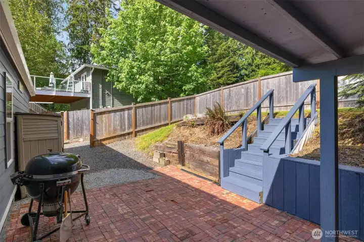 Back yard, portion is fenced, grassy dog run up by the fence