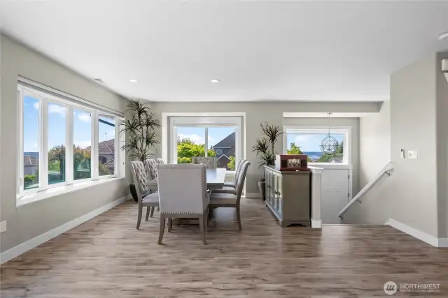 Dining room with floor to ceiling windows with views of the water and mountains