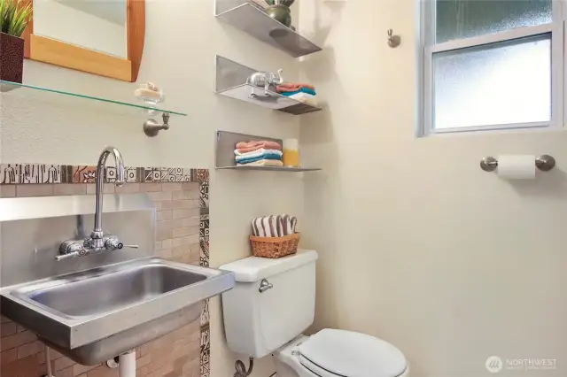 The powder room features an upcycled sink.