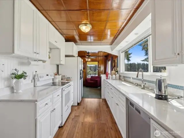 Front door view of this Beautiful Kitchen with hardwood floors and white cabinets