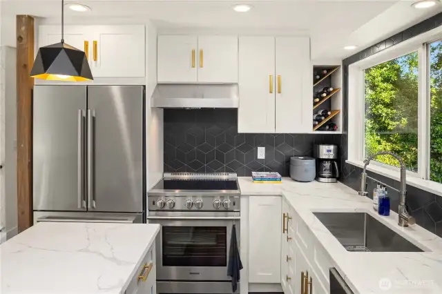 The kitchen is a functional showpiece with gleaming stainless steel appliances, solid-surface countertops, full-height backsplash, and rich cabinetry. An open layout connects effortlessly to dining and living areas for seamless entertaining....