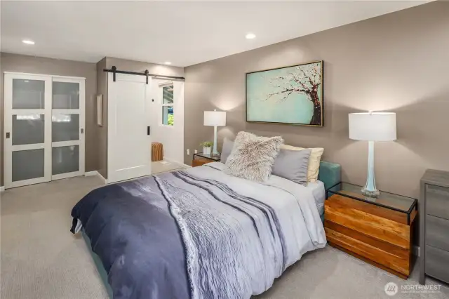 The spacious primary suite offers a peaceful retreat, featuring large windows that bathe the room in natural light, a full wall of closet space, and tranquil views of the landscaped backyard—perfect for unwinding after a long day....