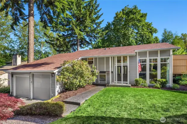 A beautifully maintained two-story home stands proudly, framed by mature landscaping and a manicured front lawn. The exterior showcases clean, timeless architecture with a charming covered porch, crisp trim details, and a tasteful blend of siding and stone accents....
