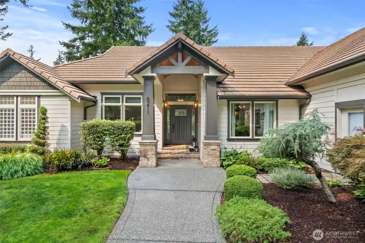 Wide front walkway flanked by mature professional landscape leads you to the Craftsman framed, covered front entry porch.