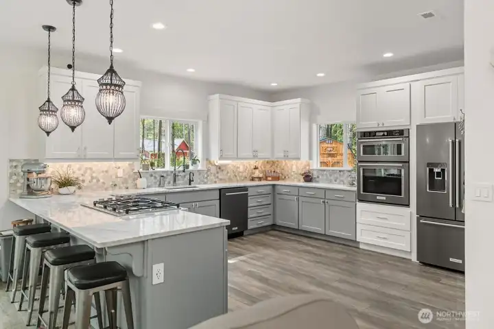 Thoughtfully designed Kitchen with outstanding cabinetry, upgraded appliances (included), quartz countertops, 10' ceiling and two big windows for natural light and a view of outbuildings and entry. Enjoy the Gas Cooktop, Microwave/Convection Oven above the Wall oven. The insta hot is perfect for tea and the re-circulation pump gives instant hot water.