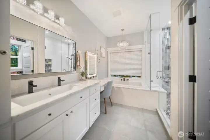 Primary Bath with dual faucets and a vanity table.  Deep Soaking Tub, Heated Tile Floors, and a Shower built for Two! Owner has plumbing stub for 2nd sink, and there is a pull out ironing center in the walk in closet. The bathroom is compartmented with heated bidet.