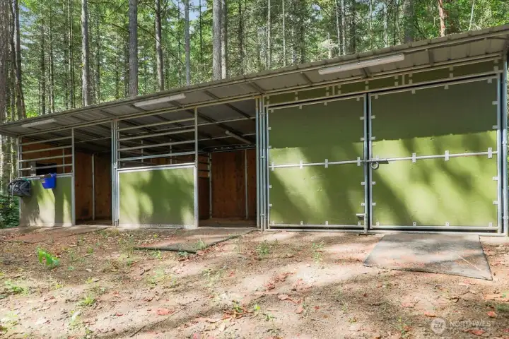 This horse shelter has two big stalls with mats and a tack room  The path to the barn is wired with lighting and the shelters have power outlets and lights. Additional fencing is needed for enclosures. This building is 12' x 36' .
