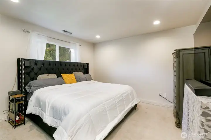 Spacious lower level bedroom with three-quarter bath, great for guests.
