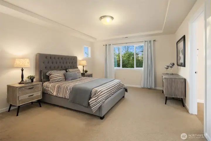 Spacious primary suite with new curtains.