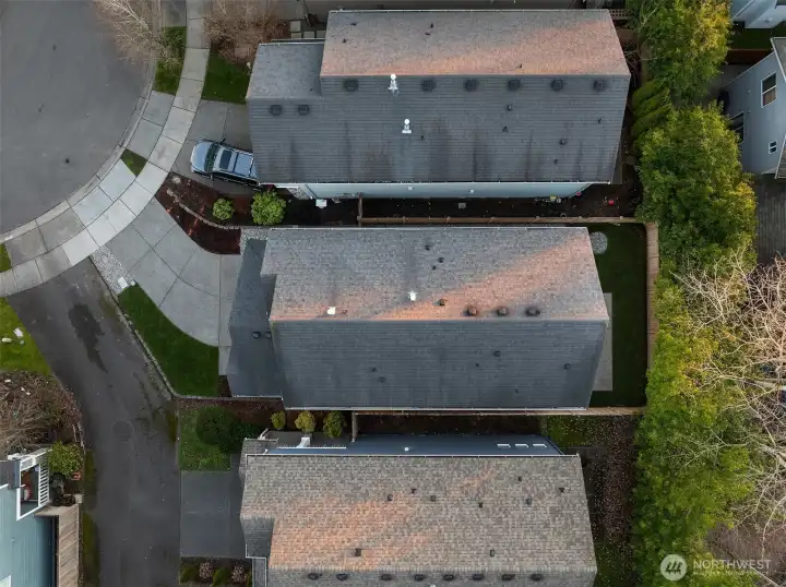 Aerial view showing the front yard, private driveway, and the fully fenced backyard.