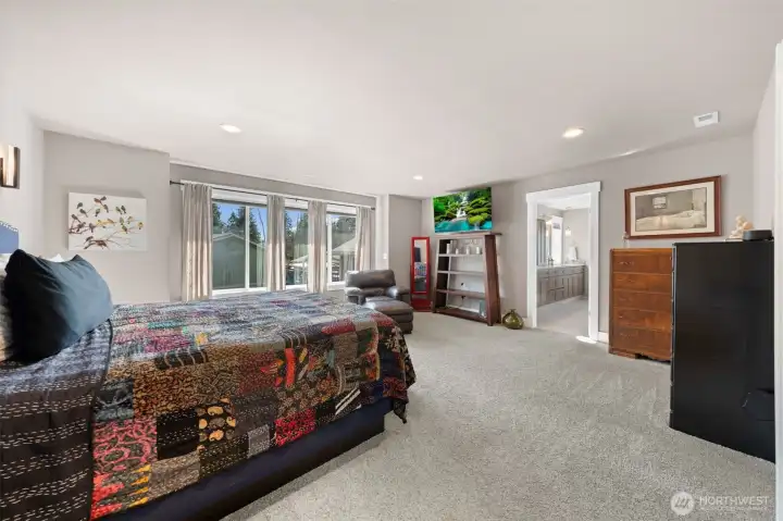 Generous primary suite with sitting area and large windows and primary bathroom