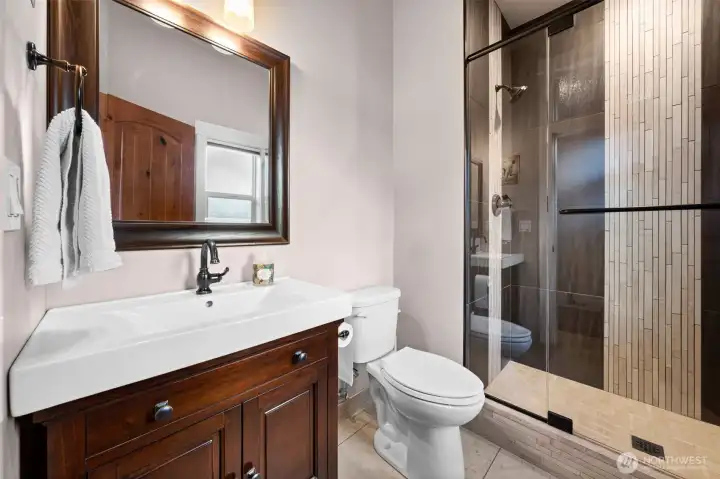 Additional bathroom with vanity storage and shower access.