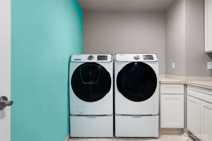 Laundry room with side-by-side washer and dryer and built-in utility sink.