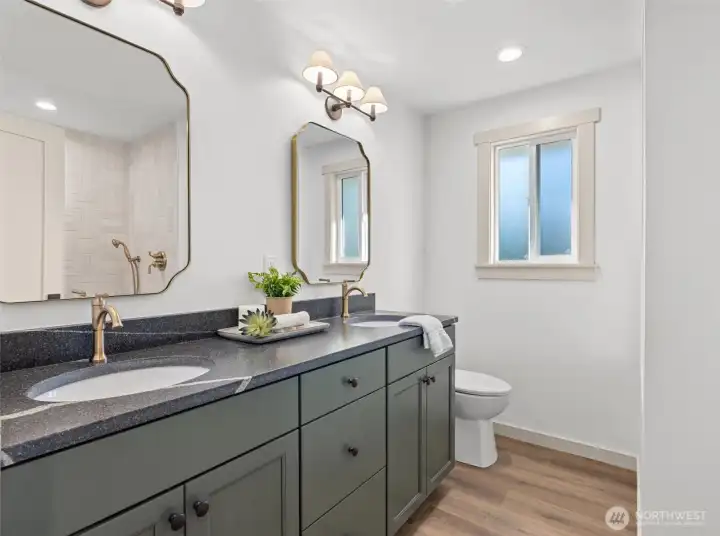 ADU bathroom with honed leather countertop, dual sinks, custom tile walk-in shower and high-end plumbing fixtures.