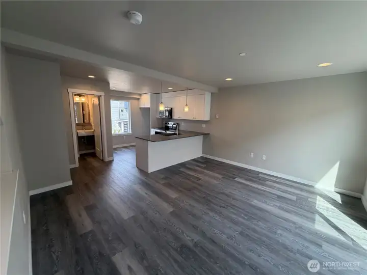 Photo of subject property. Living/Kitchen area with powder room to left of frame