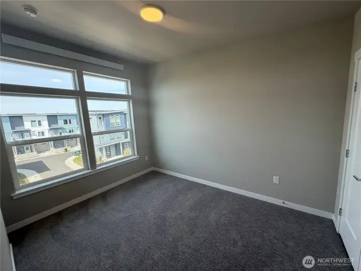 Photo of subject property. Main bedroom upstairs with transom windows, ceiling fan and French doors to closet