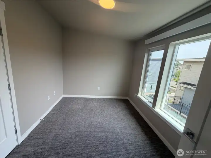 Photo of subject property. 2nd bedroom upstairs with large windows and French doors to closet