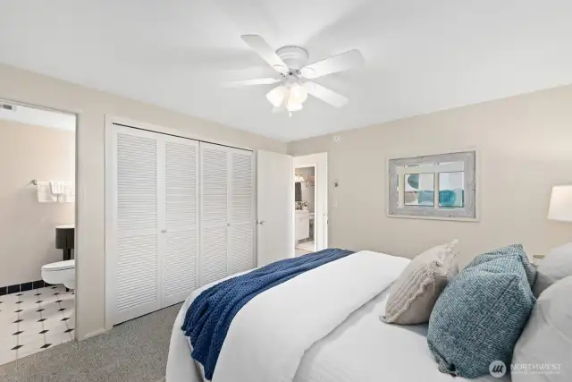 Spacious and cozy primary suite featuring double closet storage and a convenient en suite half bath.