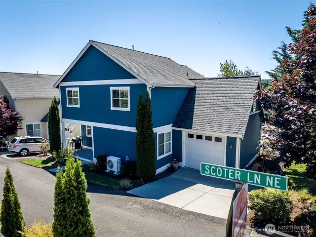 Rear of home showing roomy one car garage with extra driveway parking.