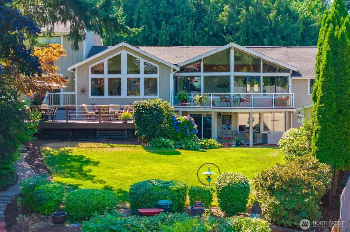 The lake facing side of the house with walls of windows and expansive decks.