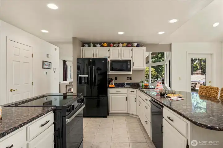 All new cabinets and granite countertops were custom made for this kitchen renovation. To the left is the laundry room with extra pantry storage.