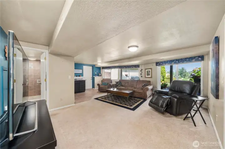 The lower level includes a spacious family room and full kitchen just ahead.  Notice the great back yard access and view.