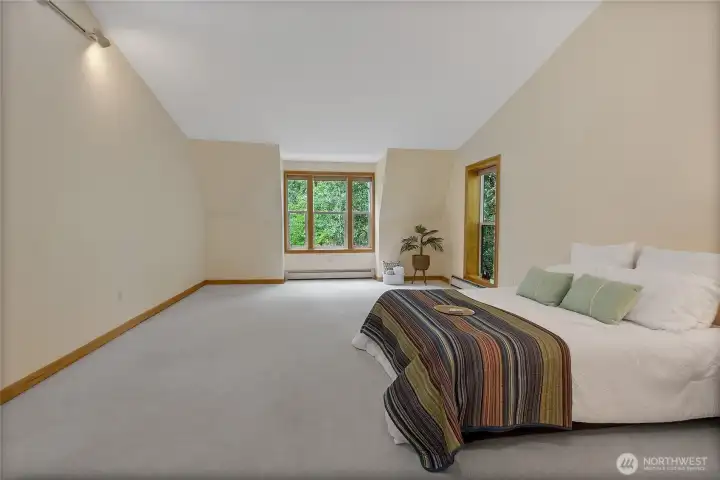 Retreat-style bedroom with abundant natural light and serene views.
