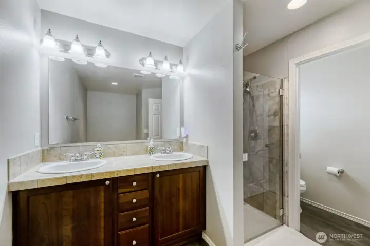 Primary bedroom ensuite bath with dual sinks and separate shower, tub, and toilet room