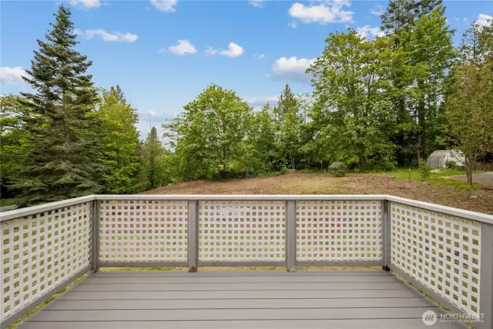 Guest cottage deck overlooking cleared backyard area.