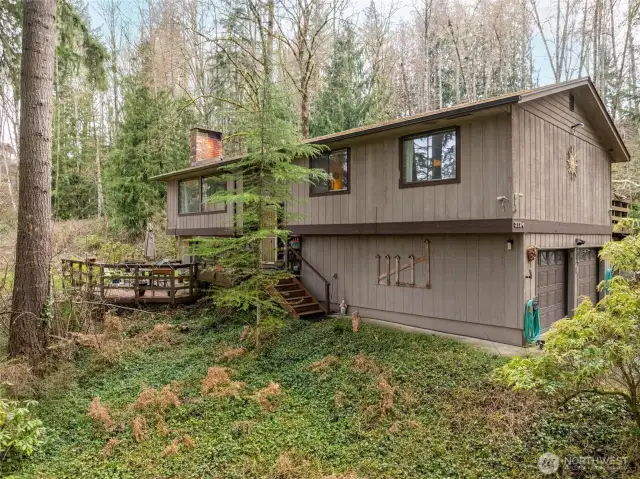 West facing front exterior of home nestled into a natural woodsy setting, so peaceful at the end of a wooded col-de-sac.
