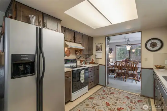 To the left of the refrigerator, there is a sliding pocket-door that leads to the main hallway and the stairs to the split-level entry.